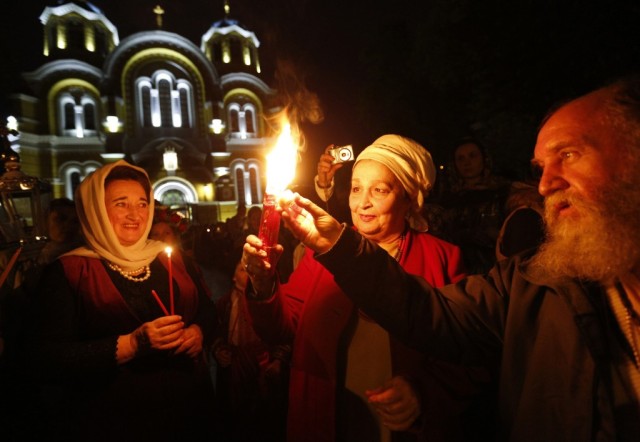 Ukrainian Orthodox believers light candles from the Holy Fire (AP)